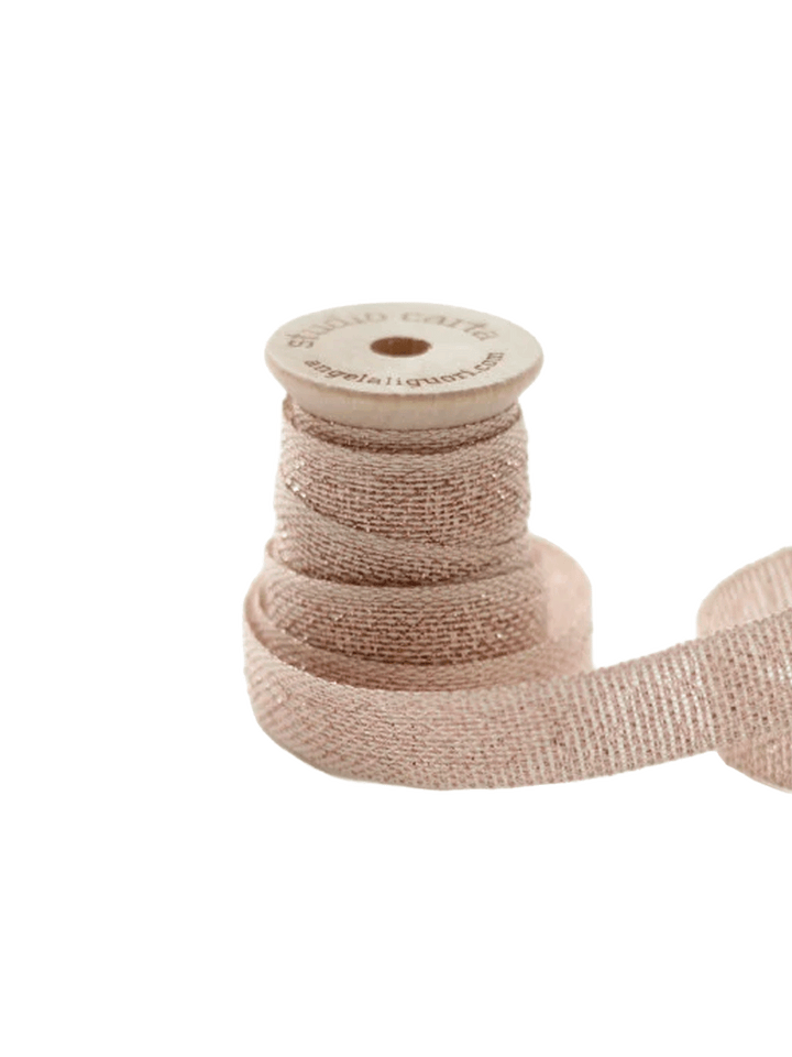 Studio Carta Metallic Loose Weave Ribbon in Natural/Rose Gold wrapped around a wooden spool with ribbon unfurled | Twentyseven Toronto