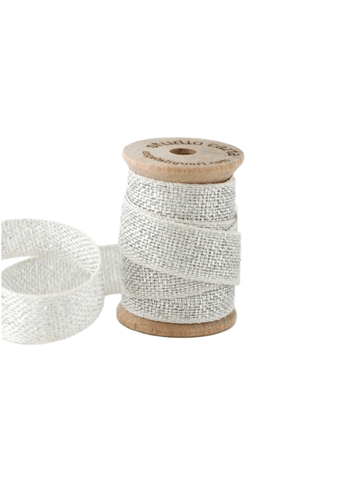 Studio Carta Metallic Loose Weave Ribbon in Natural/Silver wrapped around a wooden spool with ribbon unfurled | Twentyseven Toronto