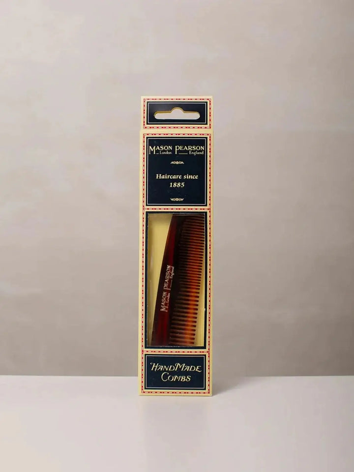 A premium tortoiseshell comb is displayed inside its traditional cream and navy blue cardboard box packaging to present the retail presentation of the Mason Pearson Styling Comb C4 | Twentyseven Toronto