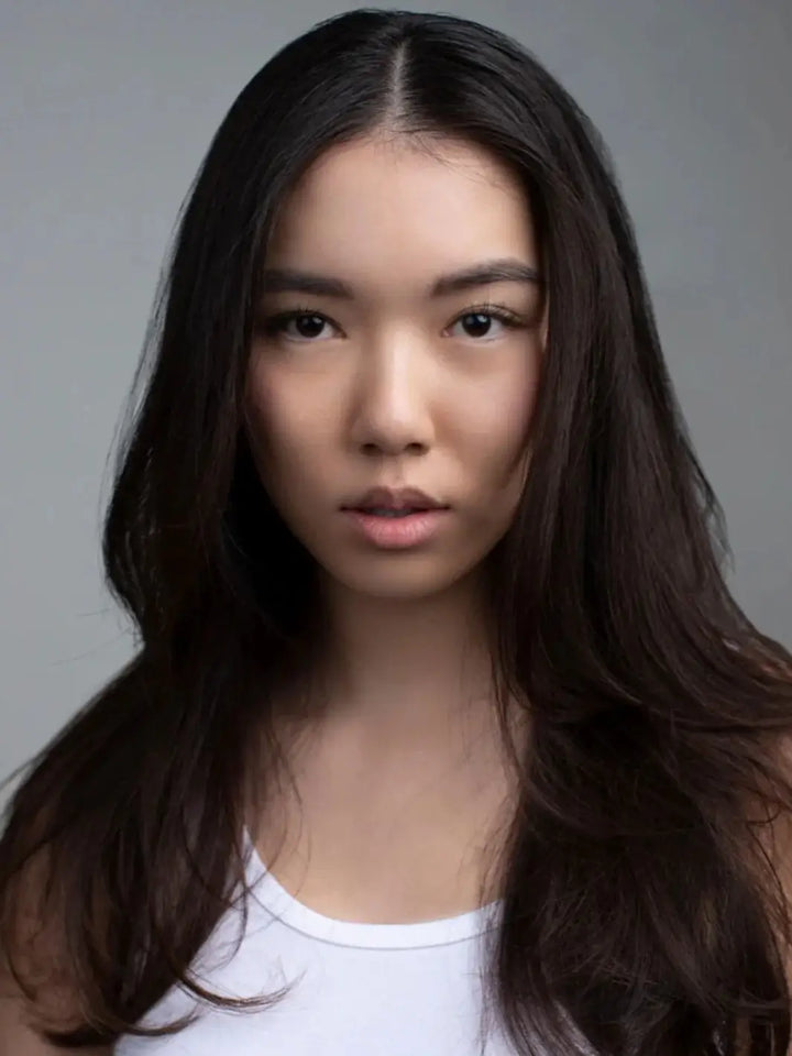 A portrait of a model showcasing healthy, voluminous dark hair with natural movement after using R+Co SUBMARINE Water Activated Enzyme Exfoliation Shampoo | Twentyseven Toronto