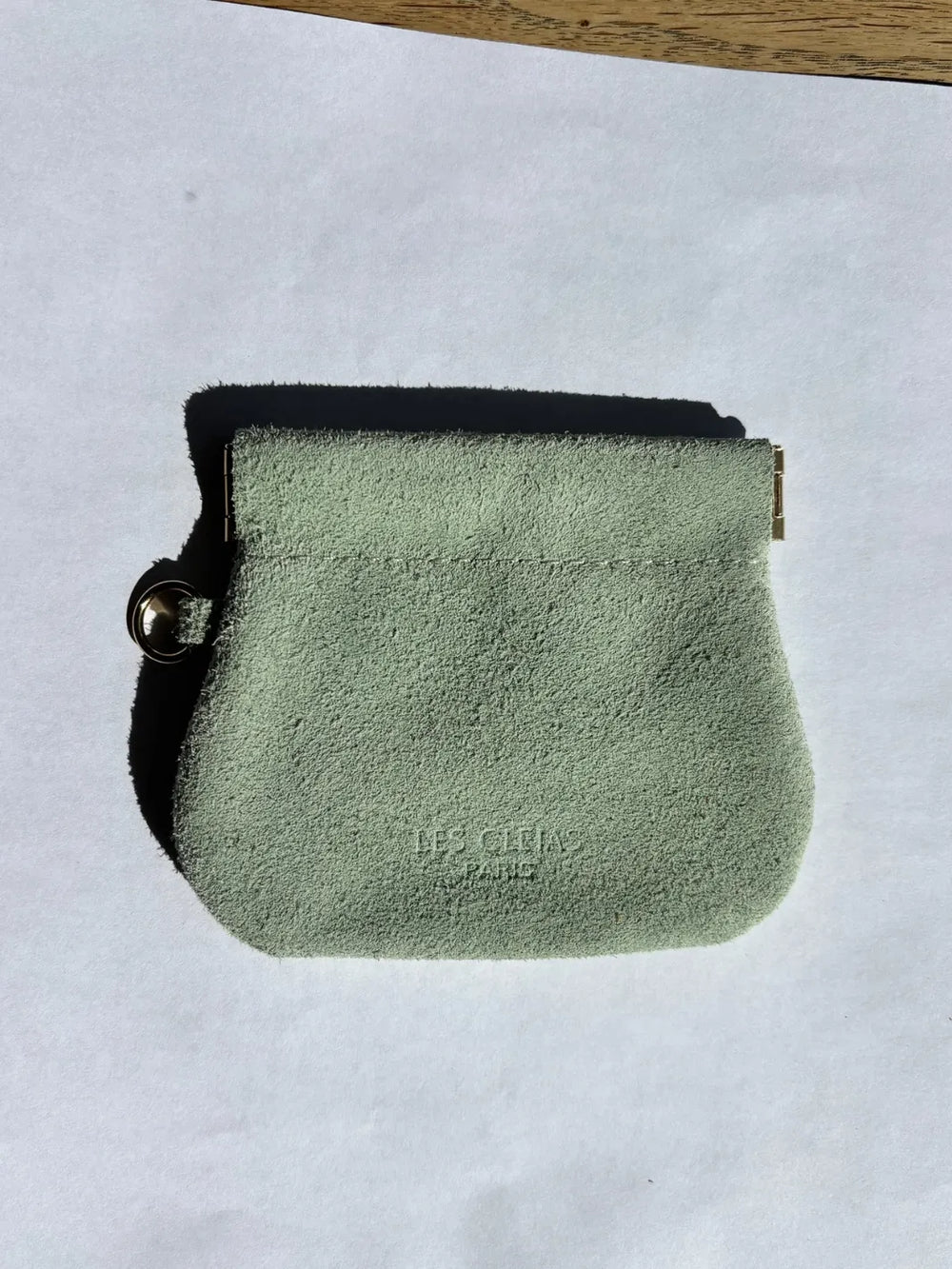 Sage green suede coin pouch with gold holder on a white background | Twentyseven Toronto