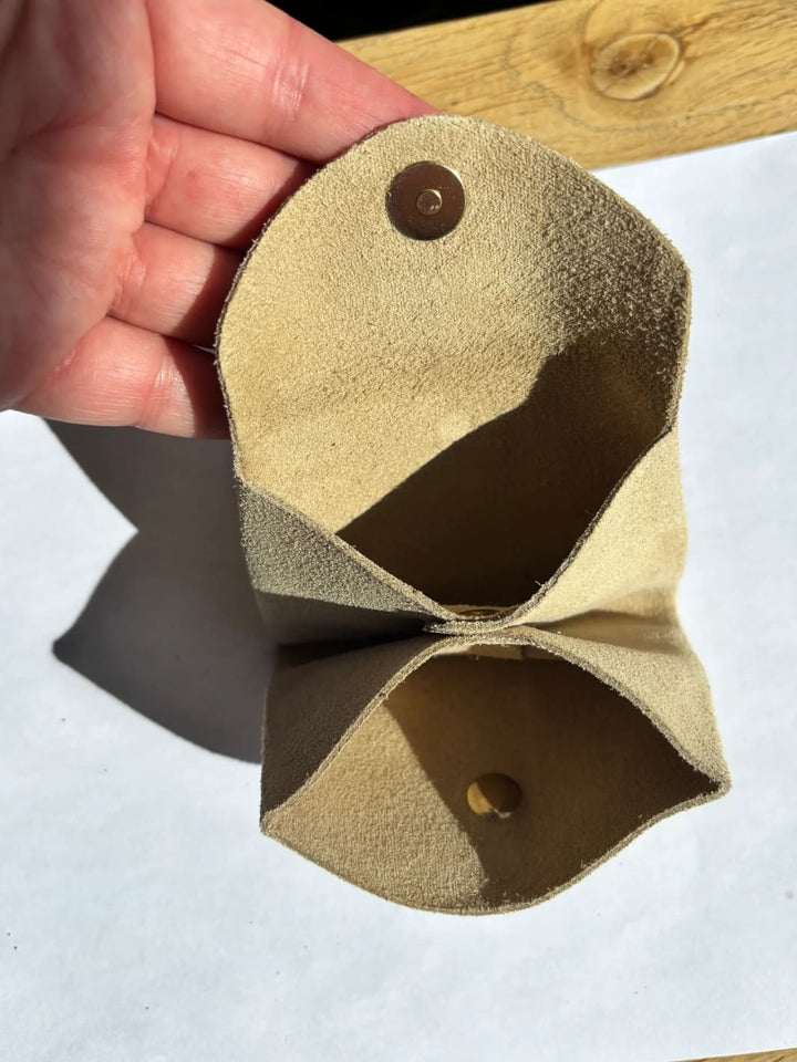 Beige suede coin purse in 'Cream' with a gold button held by hand showing inside of coin purse | Twentyseven Toronto