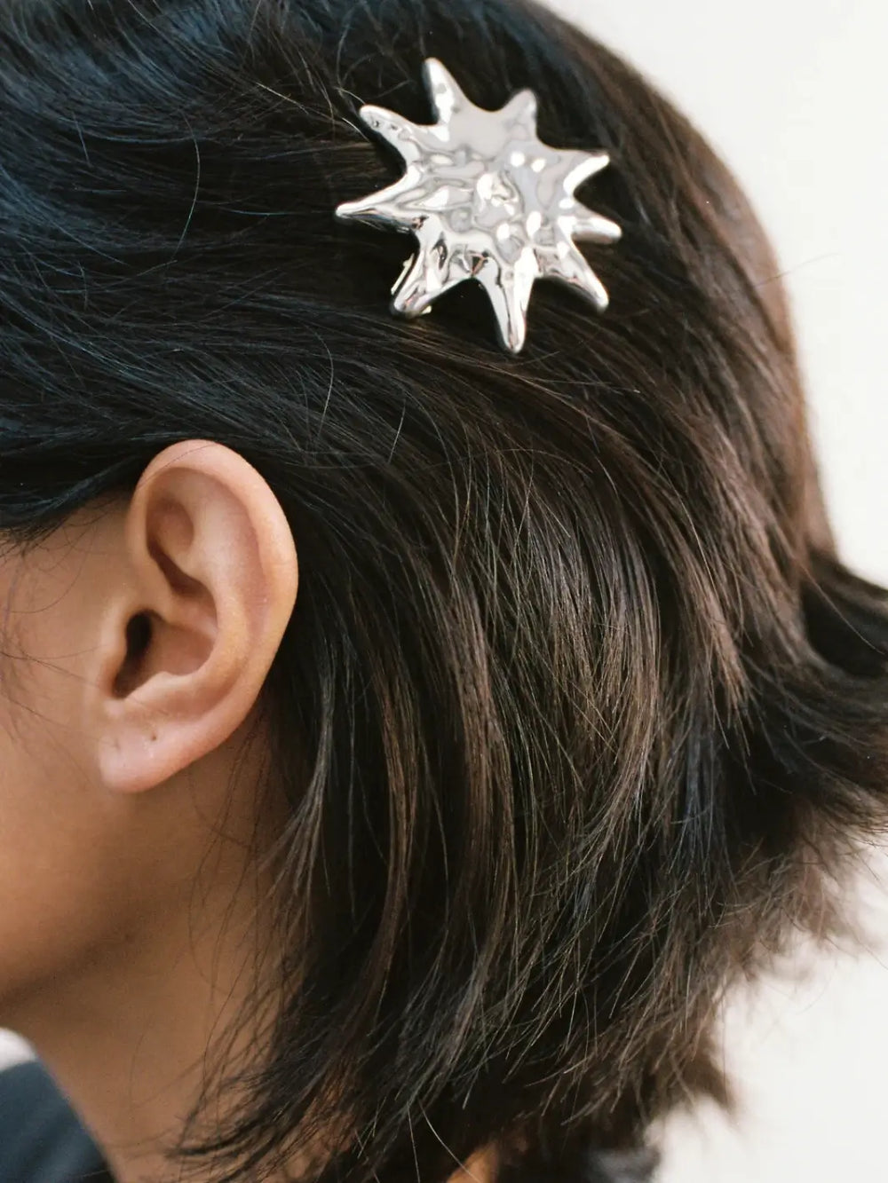 Person with dark hair wearing a high-shine, molten-textured Sun Barrette hairclip in Silver from Wolf Circus | Twentyseven Toronto