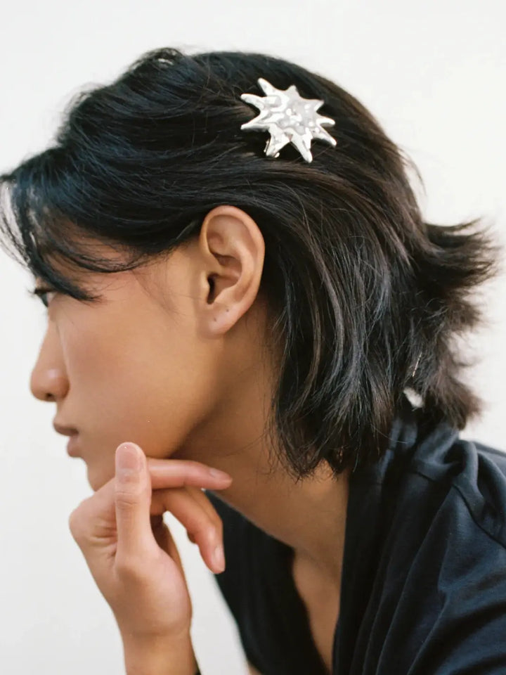 Side profile shot of a woman with a short dark bob wearing the statement Sun Barrette in Silver from Wolf Circus | Twentyseven Toronto