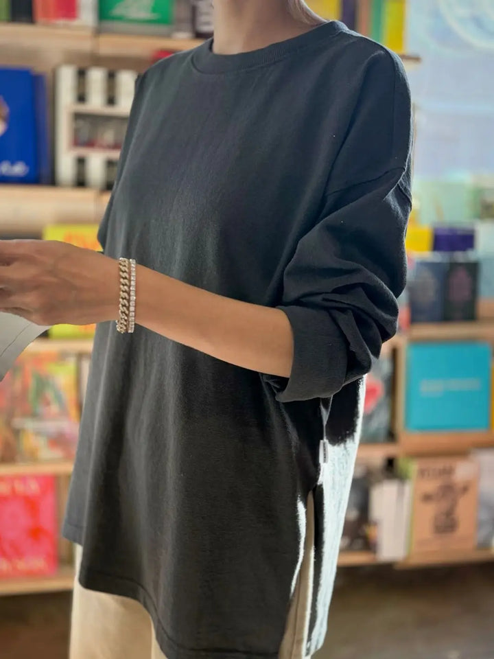 Person wearing a dark gray 'Sunday Tee' oversized sweatshirt from Le Bon Shoppe in a store setting | Twentyseven Toronto