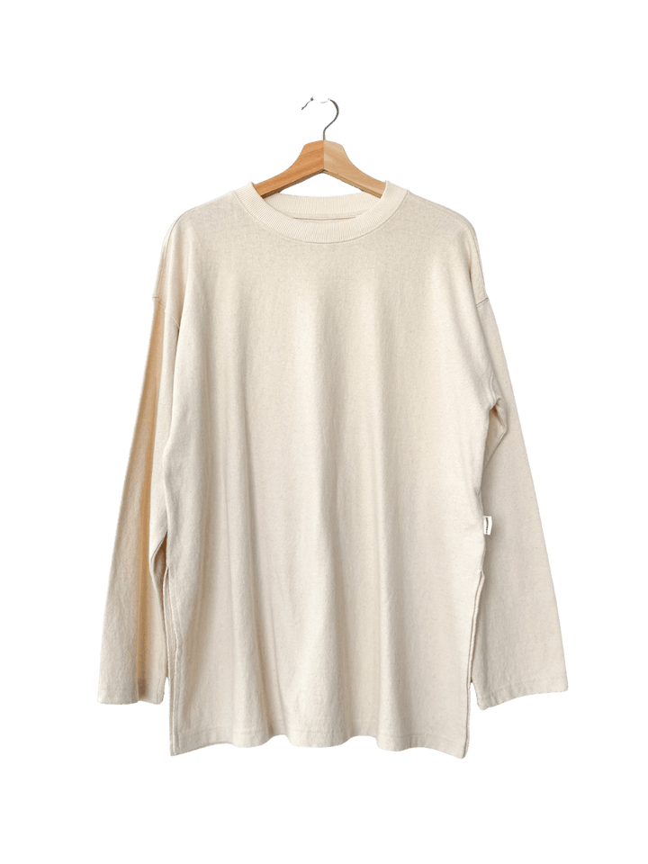 Off-white long-sleeve 'Sunday Tee' shirt in 'Naturel' on a hanger against a transparent background | Twentyseven Toronto