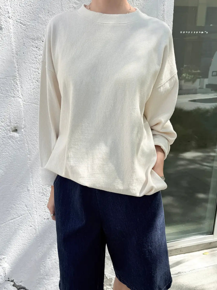 Person wearing a beige 'Sunday Tee' oversized sweatshirt from Le Bon Shoppe in an outdoor setting | Twentyseven Toronto