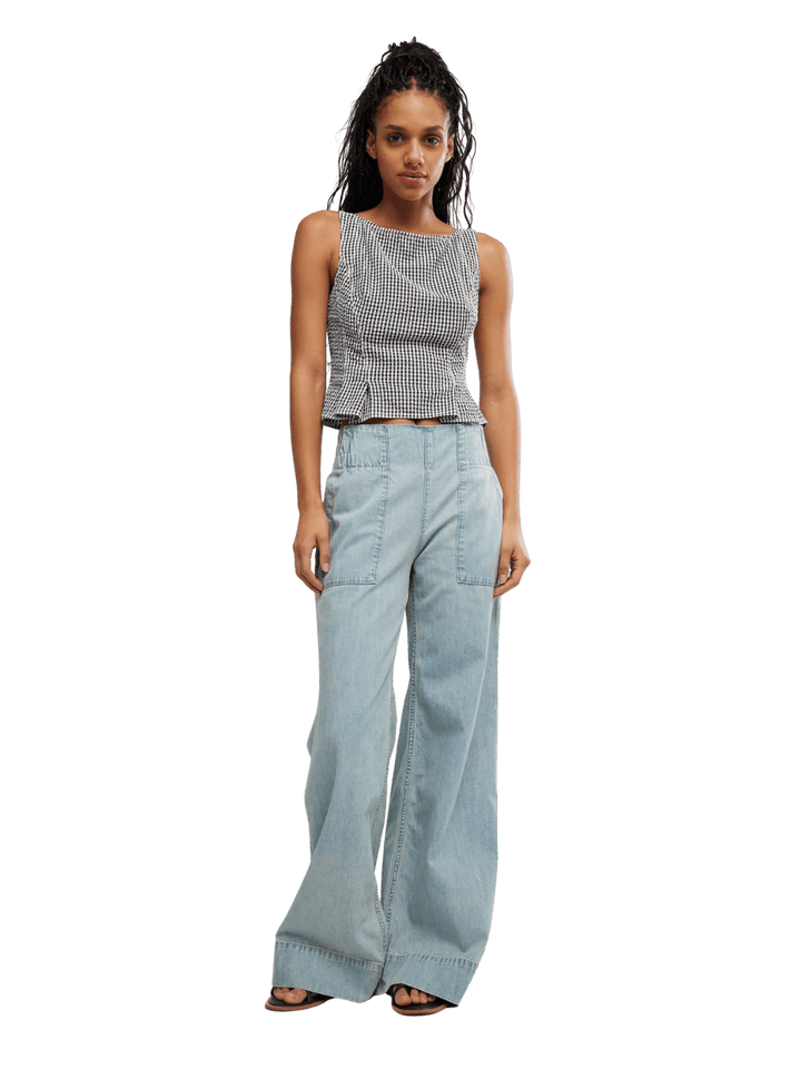Woman wearing a Free People 'Sunfaded Top' in 'Black and White Combo' checkered top and light blue jeans | Twentyseven Toronto