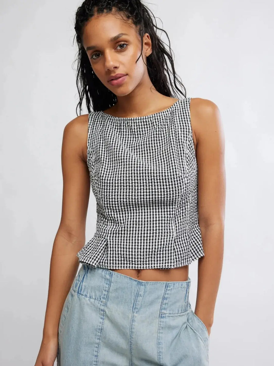 A front view shows a model wearing the Free People Sunfaded Top in Black and White Combo, highlighting its gingham pattern, high neckline, and slightly flared waistline | Twentyseven Toronto