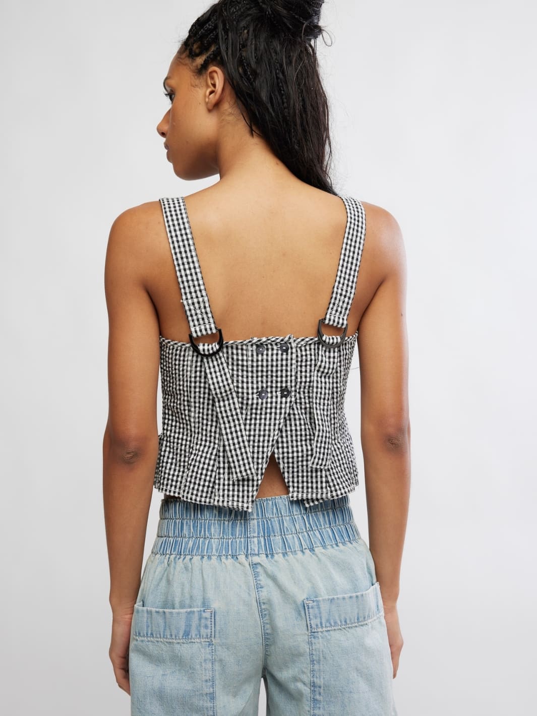 Woman wearing a Free People 'Sunfaded Top' in 'Black and White Combo' checkered top, back view | Twentyseven Toronto