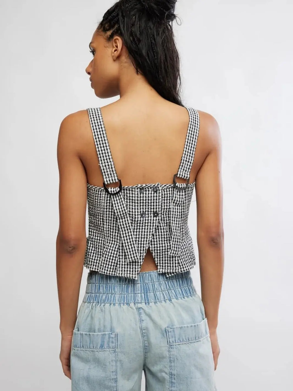 A rear view reveals the open lower-back design, button closures, and D-ring strap adjusters on the Free People Sunfaded Top in Black and White Combo | Twentyseven Toronto
