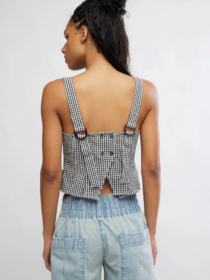A rear view reveals the open lower-back design, button closures, and D-ring strap adjusters on the Free People Sunfaded Top in Black and White Combo | Twentyseven Toronto