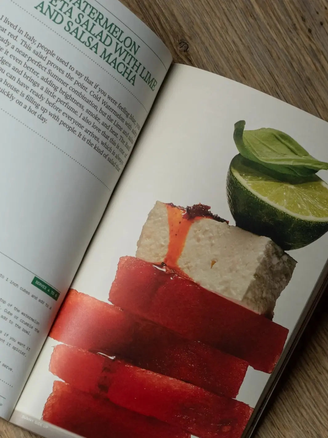 An open recipe page from the Flamingo Estate Sunny Side Up Recipe Book showing a photo of a stacked watermelon and feta salad topped with lime and basil | Twentyseven