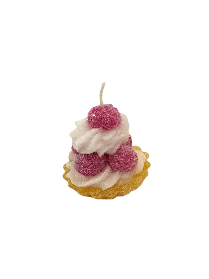 Candle shaped like a tart with white frosting and red berries from Cereria Introna on a white background | Twentyseven Toronto