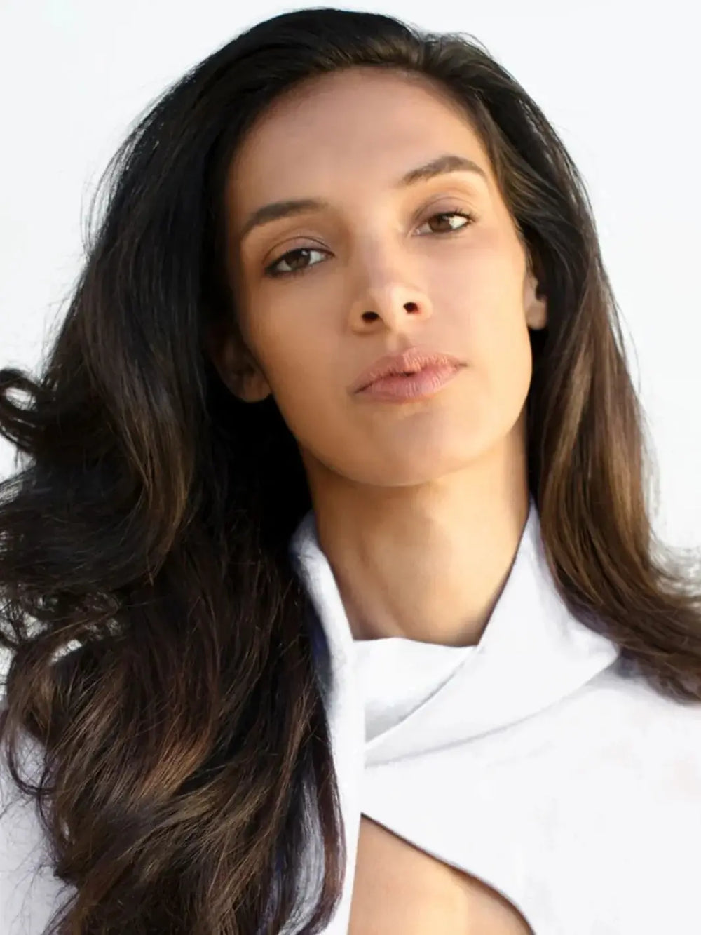 A model with long, flowing, and voluminous dark hair showcases healthy shine and body after using R+Co TELEVISION Perfect Hair Shampoo | Twentyseven Toronto