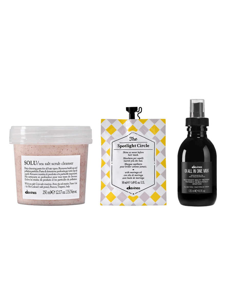 Three Davines hair care products including SOLU Sea Salt Scrub (250ml), The Spotlight Circle (50ml), and OI All in One Milk (135ml) on a transparent background | Twentyseven Toronto