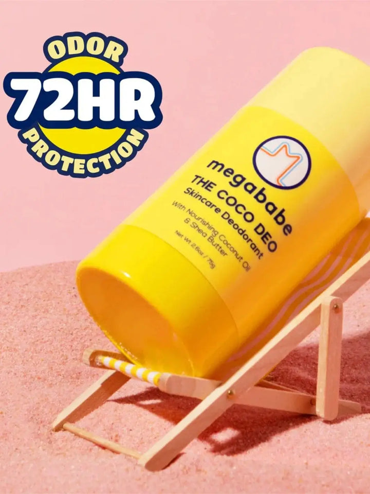 A vibrant yellow deodorant stick rests on a miniature wooden beach chair on pink sand, highlighting the long-lasting freshness of the Megababe The Coco Deo | Twentyseven Toronto