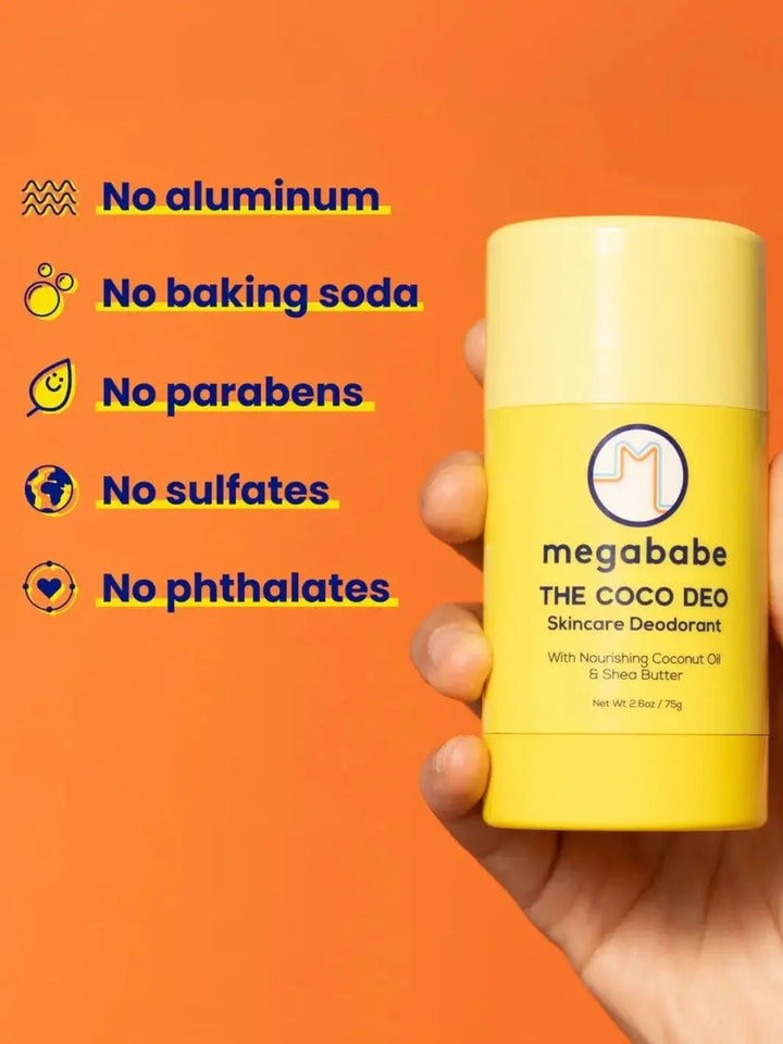 A close-up view shows a hand holding a yellow deodorant container against a bright orange background alongside a list of ingredient exclusions for the Megababe The Coco Deo | Twentyseven Toronto