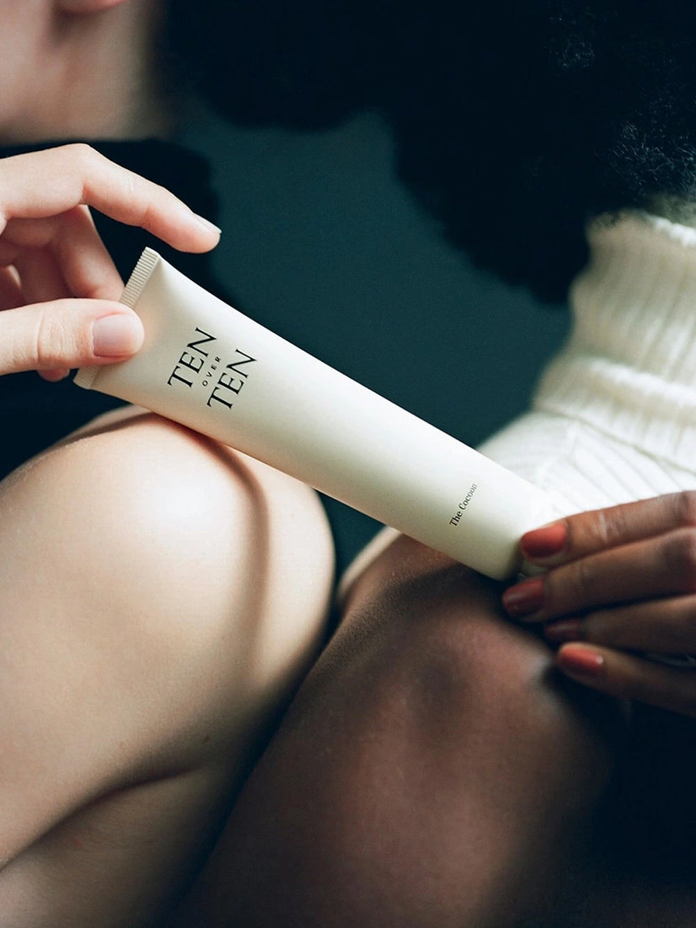 TENOVERTEN The Cocoon Hand + Foot Cream held in hand for a lifestyle product shot | Twentyseven Toronto