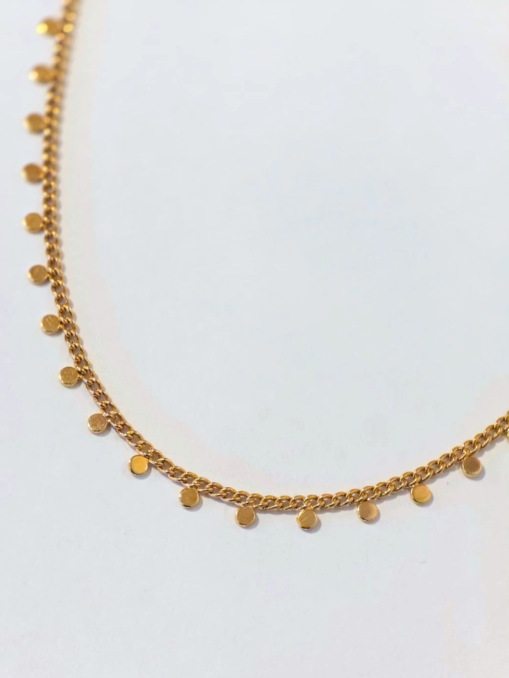 Gold plated necklace with small round pendants on a light gray background | Twentyseven Toronto