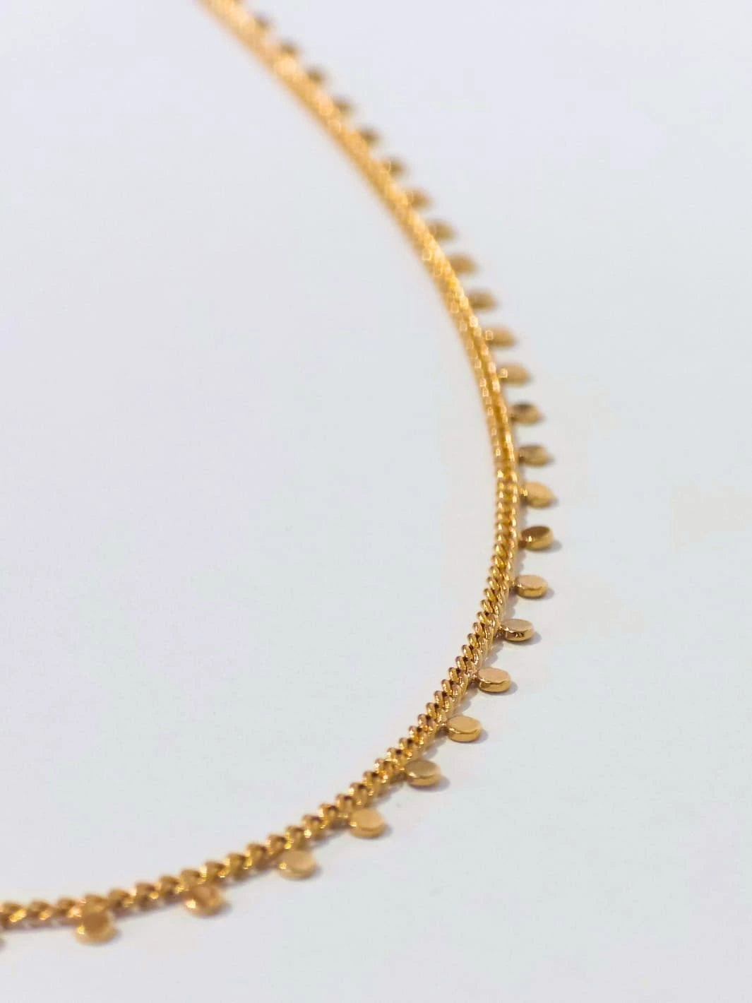 Gold plated necklace with small round pendants on a light gray background | Twentyseven Toronto
