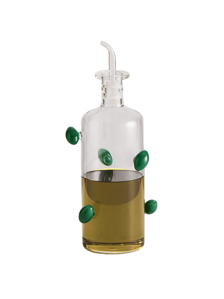 Glass olive dispenser bottle from Maison Balzac decorated with green olives on a transparent background | Twentyseven Toronto