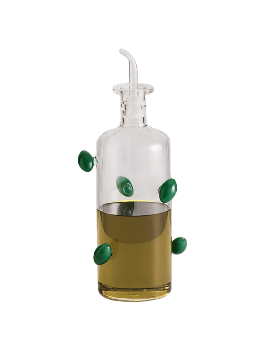 Glass olive dispenser bottle from Maison Balzac decorated with green olives on a transparent background | Twentyseven Toronto