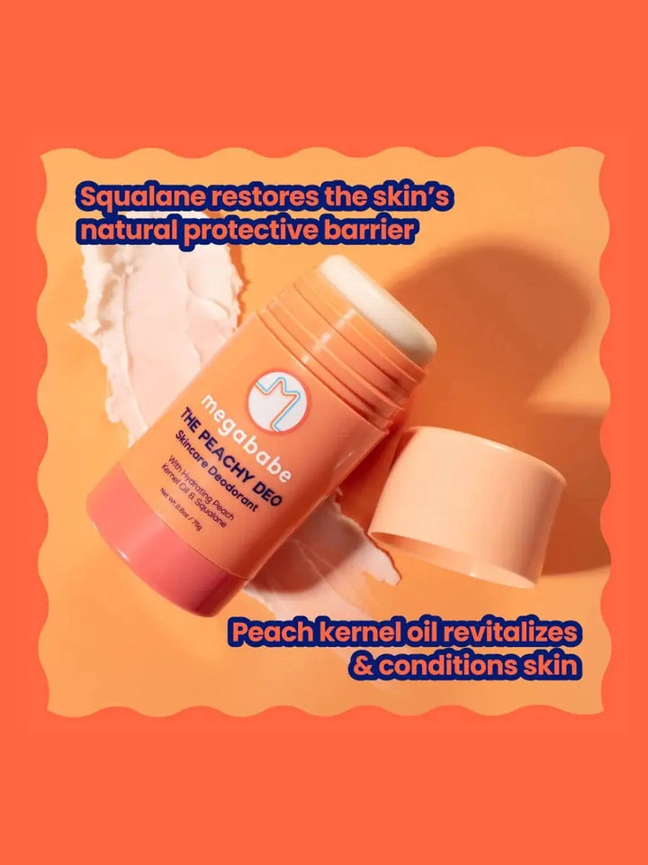 An open container of Megababe The Peachy Deo lies across streaks of white lotion to highlight its key ingredients, squalane and peach kernel oil | Twentyseven Toronto