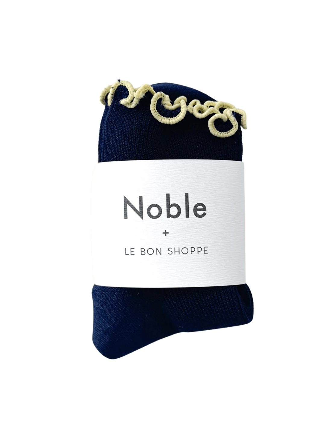 A navy sock with yellow edges of The Petite Ruffled Modal Socks in Butter / Navy from Le Bon Shoppe with a white paper brand band that reads "Noble + LE BON SHOPPE" | Twentyseven Toronto