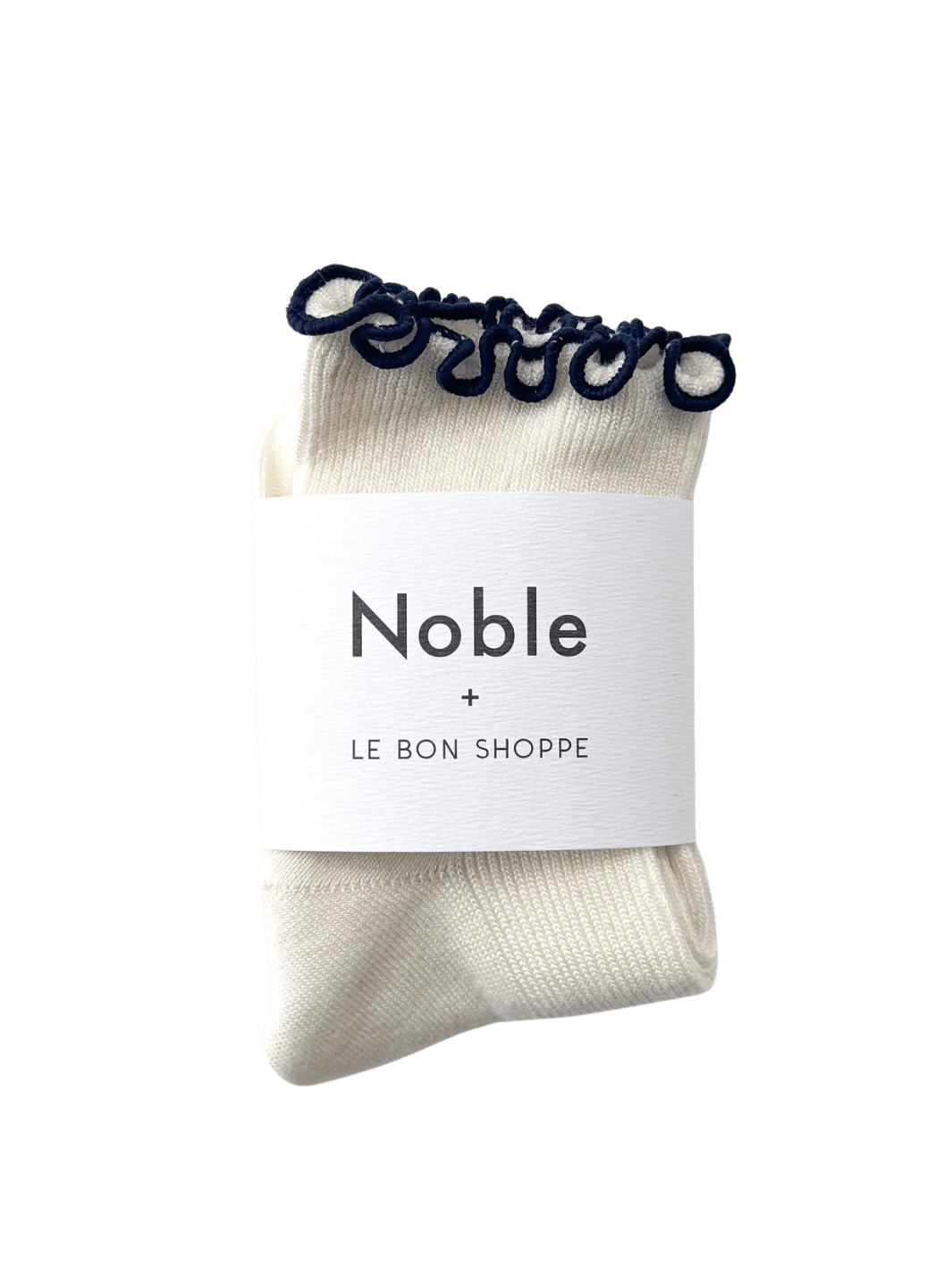 A pair of The Petite Ruffled Modal Socks in Soft White / Navy from Le Bon Shoppe is displayed with its white "Noble + LE BON SHOPPE" collaborative packaging band | Twentyseven Toronto