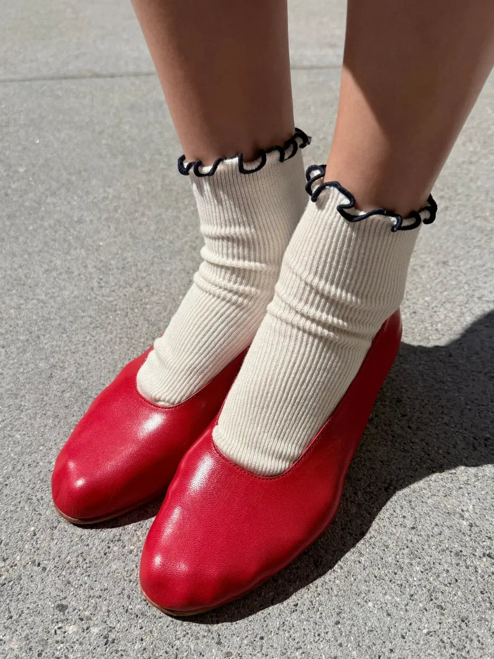White and navy trim Petite Ruffled Modal Socks in Soft White / Navy from Le Bon Shoppe styled with vibrant red leather slip-on shoes | Twentyseven Toronto