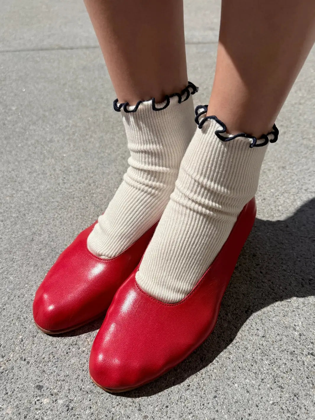 White and navy trim Petite Ruffled Modal Socks in Soft White / Navy from Le Bon Shoppe styled with vibrant red leather slip-on shoes | Twentyseven Toronto