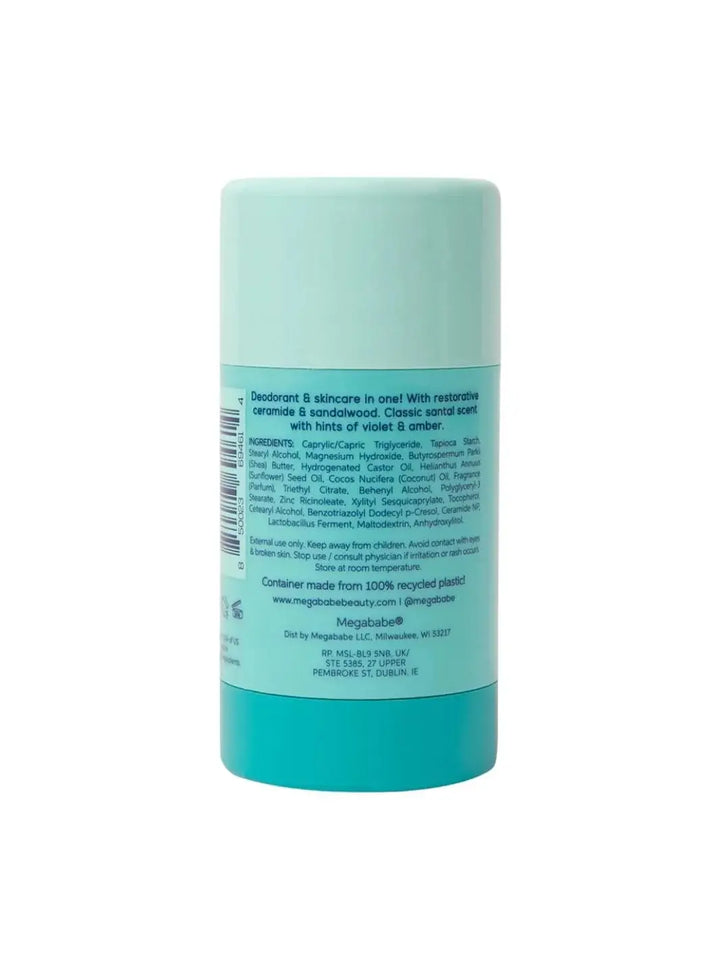 The back label of a light blue deodorant stick is shown vertically against a white background to display the ingredients list and details for Megababe The Santal Deo | Twentyseven Toronto