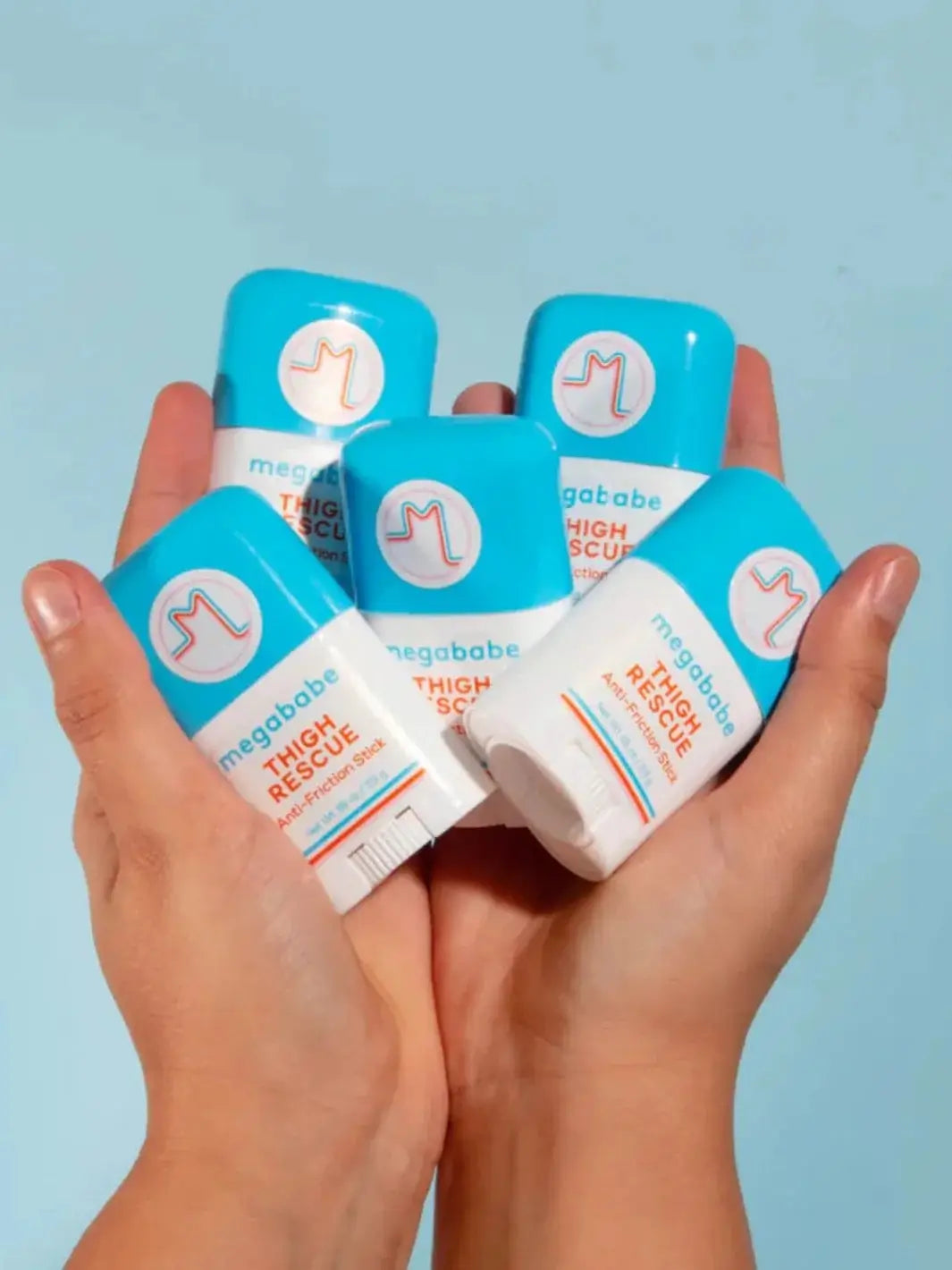 A hand slides a Megababe Thigh Rescue Mini anti-friction stick into the back pocket of a pair of blue jeans to highlight how easily it fits on the go | Twentyseven Toronto
