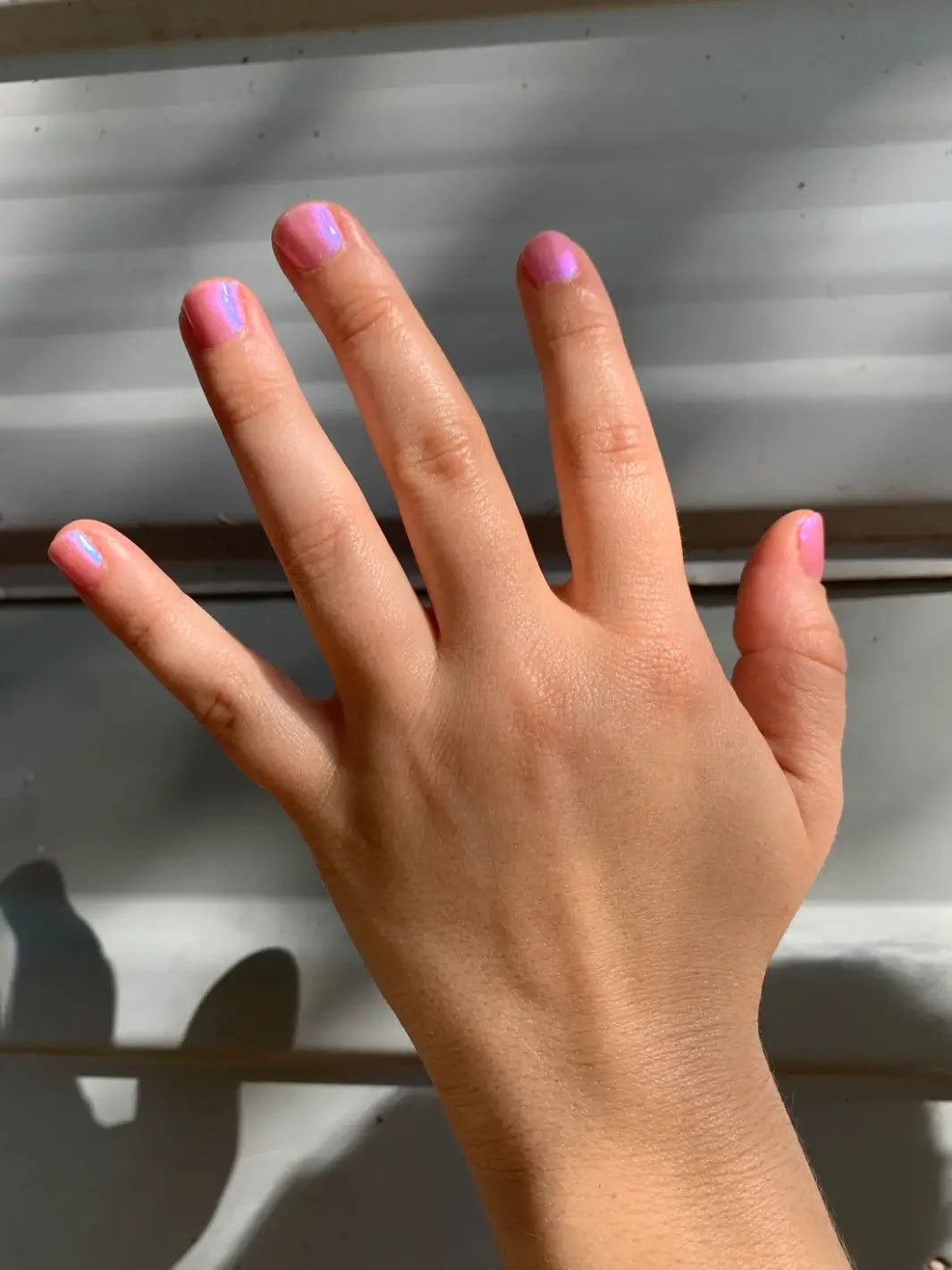 A hand with short, neatly manicured nails displays the vibrant blue shimmer of Death Valley Nails Throwing Spaghetti At The Wall Of Your Heart To See What Sticks Nail Polish | Twentyseven Toronto