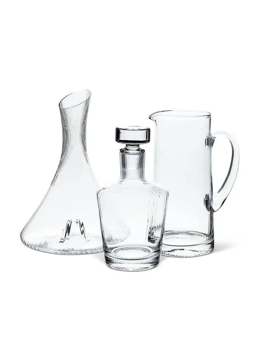 A collection of clear, ribbed glassware featuring a wine decanter, a liquor decanter with a stopper, and an Abbott Collection Tight Optic Jug displayed together on a plain white background | Twentyseven Toronto