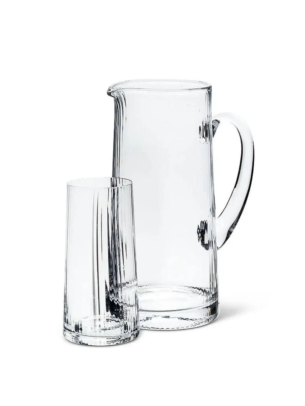 An empty, clear glassware set featuring an Abbott Collection Tight Optic Jug with a smooth handle alongside a matching ribbed highball glass against a solid white background | Twentyseven Toronto