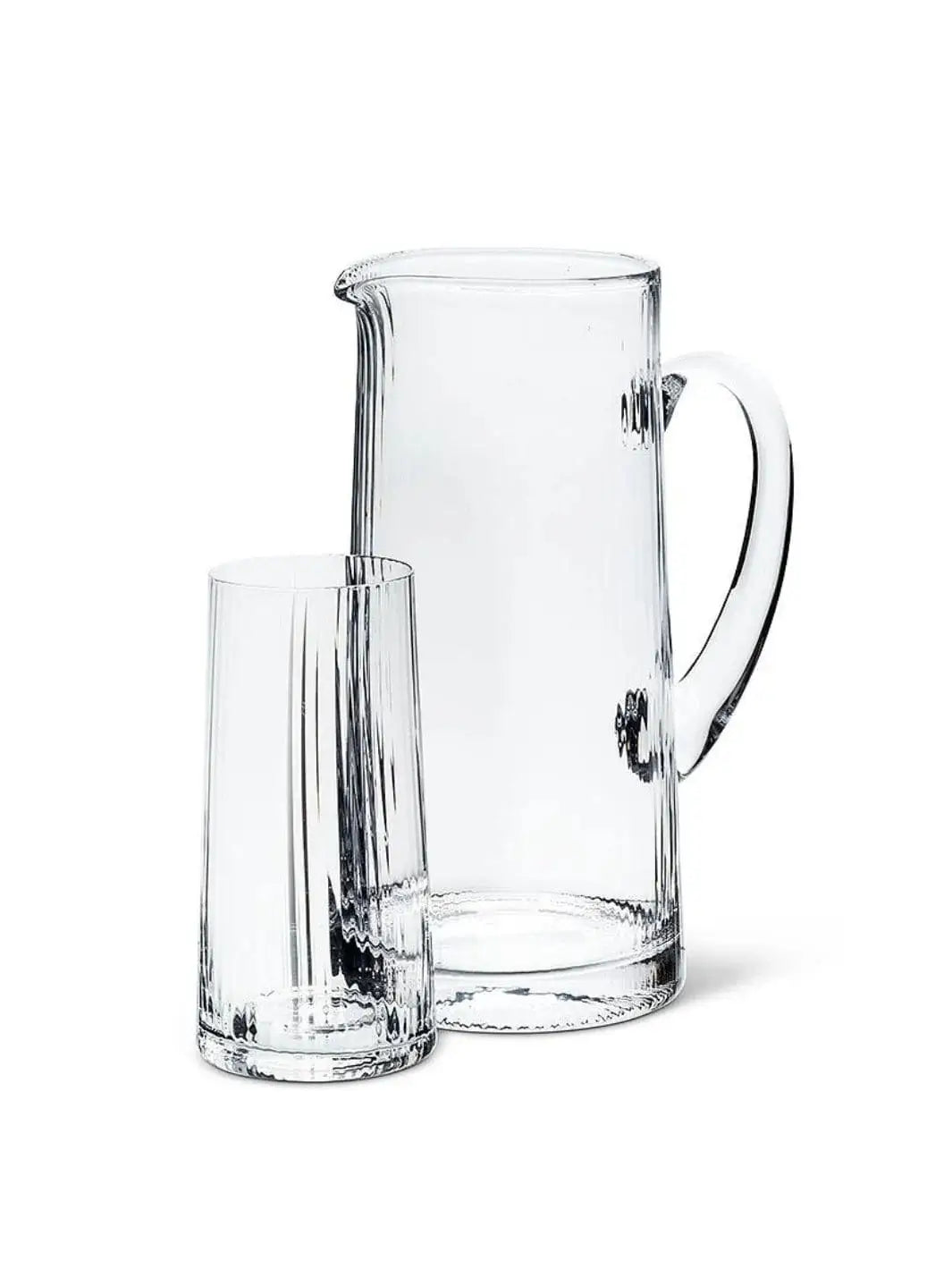 An empty, clear glassware set featuring an Abbott Collection Tight Optic Jug with a smooth handle alongside a matching ribbed highball glass against a solid white background | Twentyseven Toronto