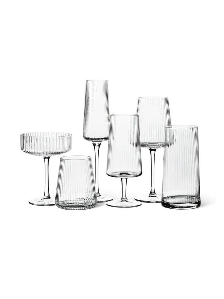 A collection of empty, ribbed modern glass stemware and tumblers from Abbott Collection against a white background | Twentyseven Toronto