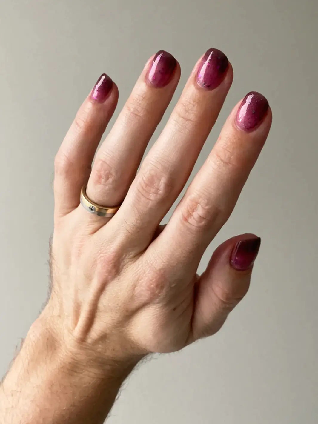 Hand with gradient glittery pink and purple nails using 'Till Death Do Us Part' nail polish by Death Valley Nails on a white background | Twentyseven Toronto