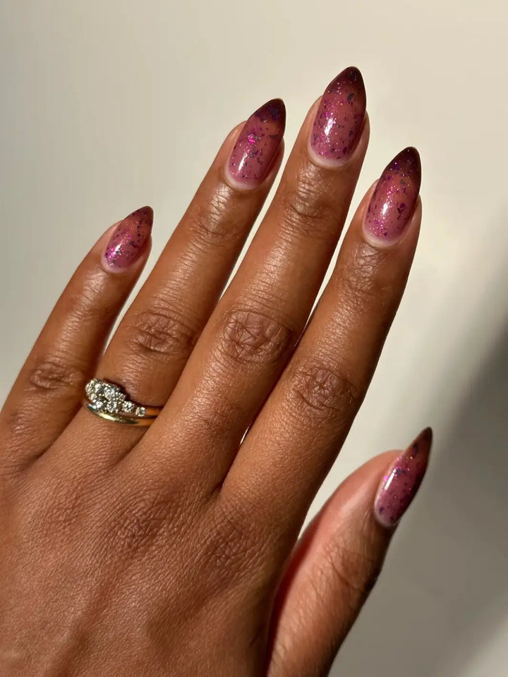 Hand with long purple gradient nails using 'Till Death Do Us Part' nail polish by Death Valley Nails wearing a diamond ring on a neutral background | Twentyseven Toronto