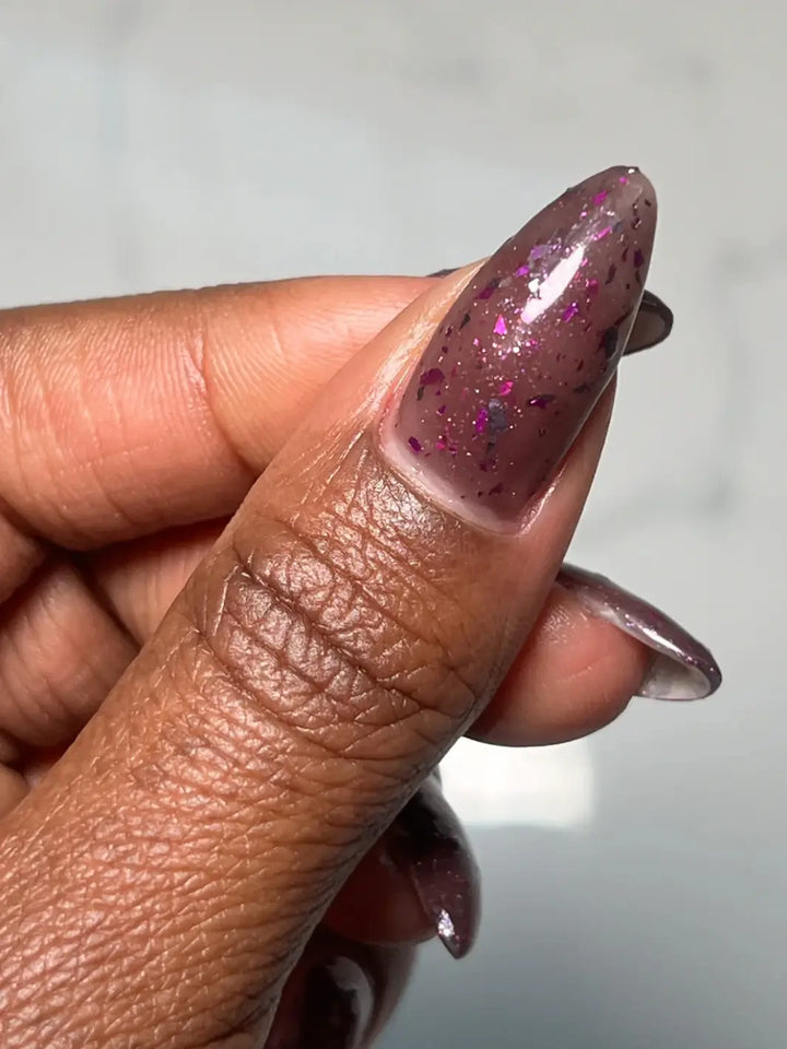 Hand with long glittery purple nails using 'Till Death Do Us Part' nail polish by Death Valley Nails on a marble background | Twentyseven Toronto