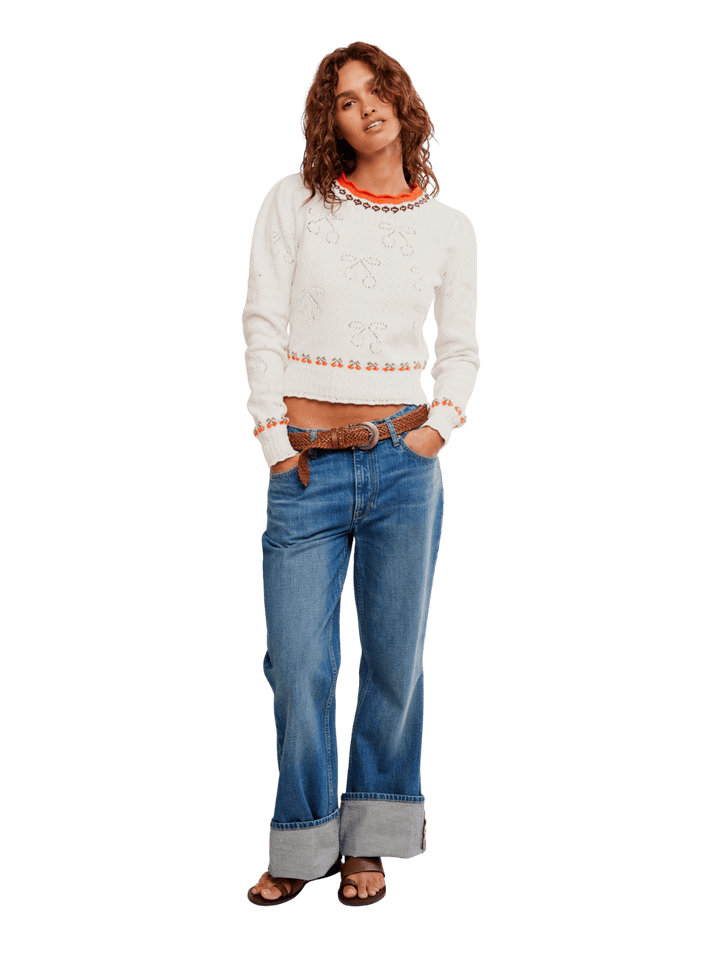 Woman wearing a white sweater from Free People Tilly Pullover in 'Coconut Milk Combo' and blue jeans | Twentyseven Toronto