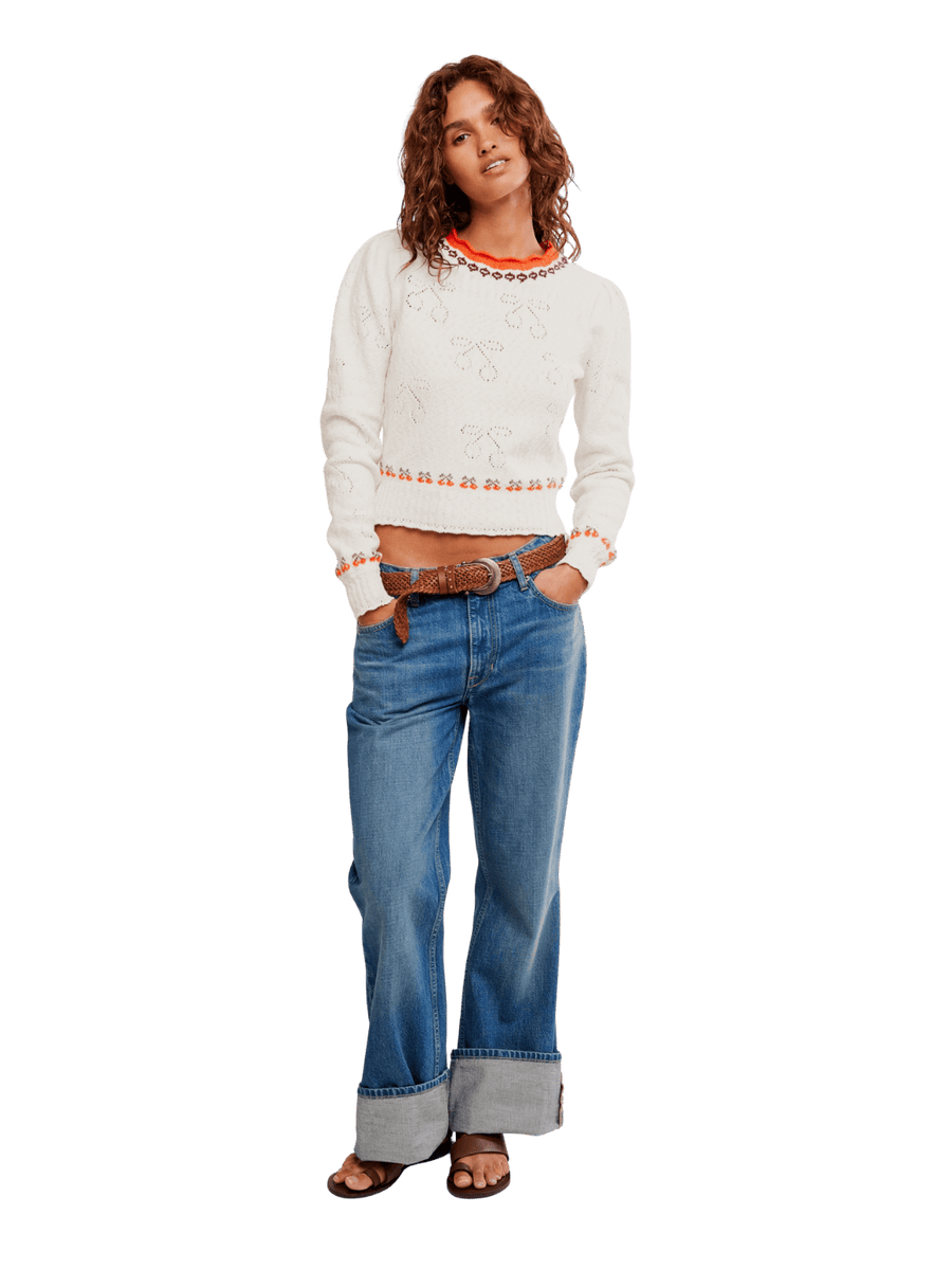 Woman wearing a white sweater from Free People Tilly Pullover in 'Coconut Milk Combo' and blue jeans | Twentyseven Toronto