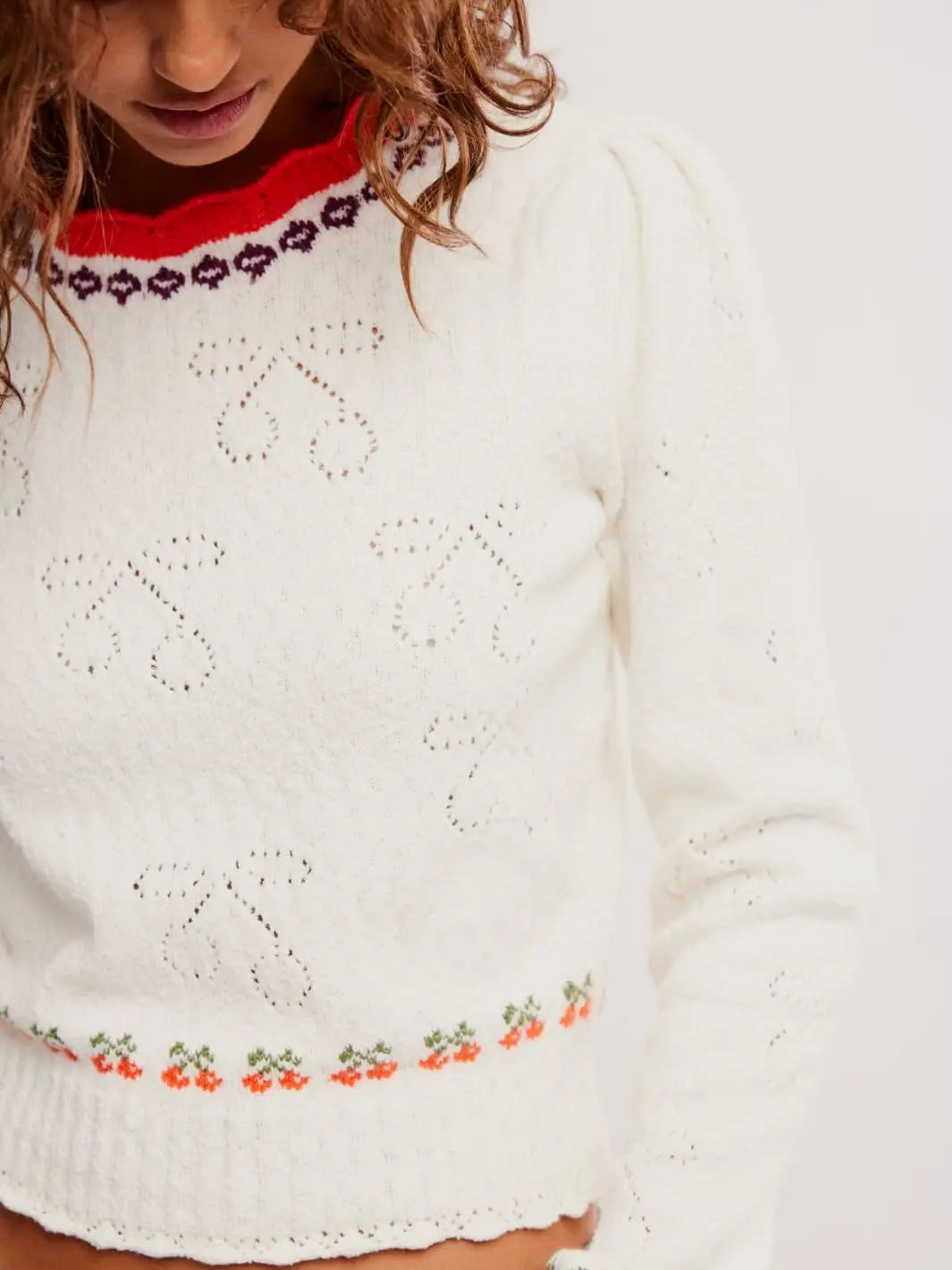 Close up of woman wearing Tilly Pullover in 'Coconut Milk Combo' white sweater with cherry patterns from Free People | Twentyseven Toronto