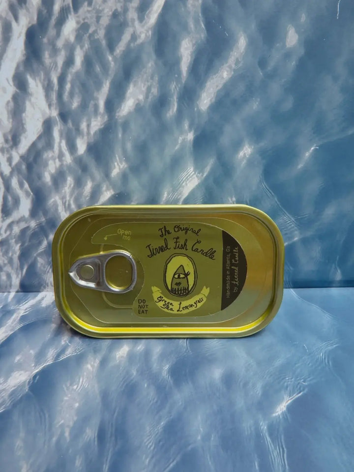 Tin of Tinned Fish Candle with 'Green Tea Lemongrass' scent on a blue background | Twentyseven Toronto