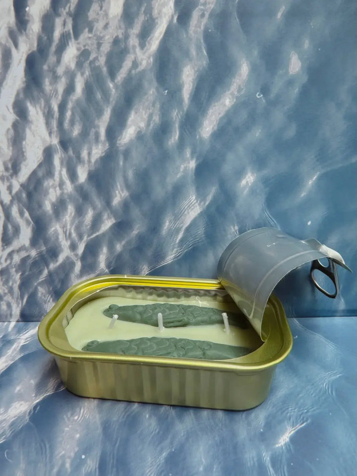 Open tin of Tinned Fish Candle with 'Green Tea Lemongrass' scent on a blue background | Twentyseven Toronto