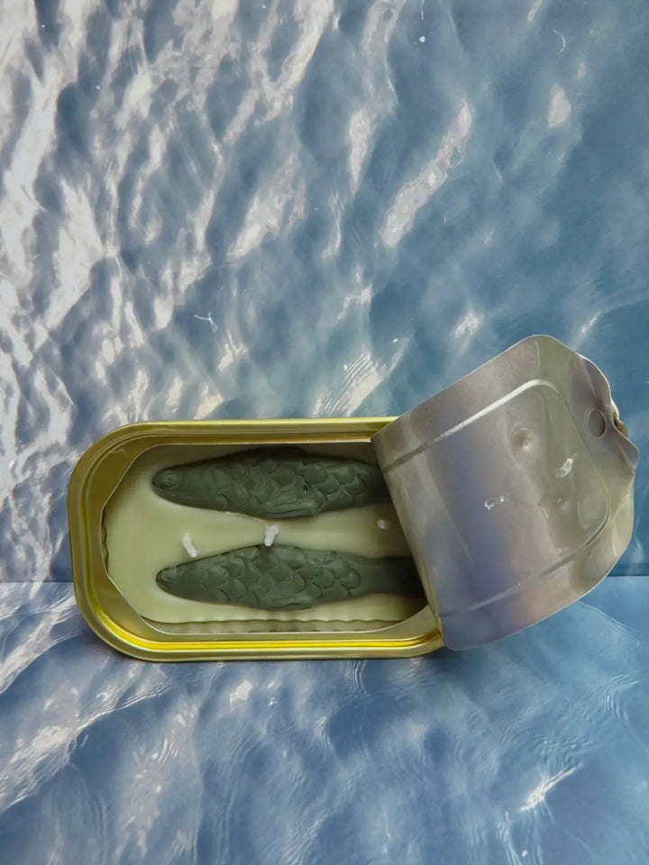 Open tin of Tinned Fish Candle with 'Green Tea Lemongrass' scent on a blue background | Twentyseven Toronto