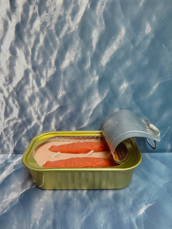 Open tin of Tinned Fish Candle with 'Oakmoss and Amber' scent on a blue background | Twentyseven Toronto