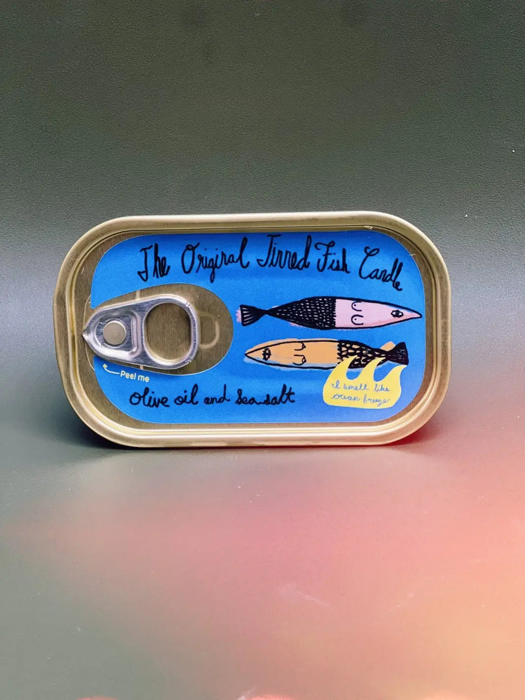 Tinned Fish Candle with artwork on a gray and pink background | Twentyseven Toronto